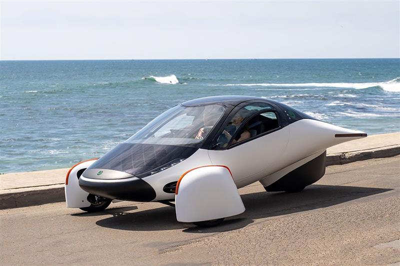 Aletheia Marketing & Media's client Aptera, the first futuristic solar power car riding on a street right next to the ocean.
